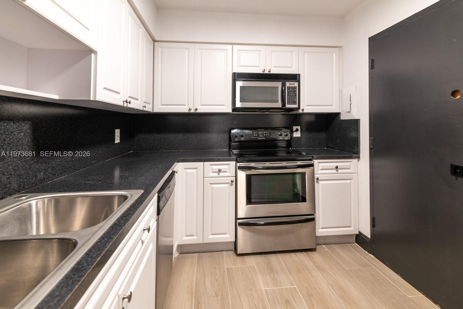 9225 Collins Avenue, Unit 1010 Surfside, FL 33154 - Photo 8 of 25 a kitchen with a stove and a microwave