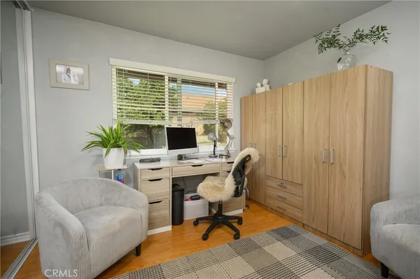 a view of a workspace with furniture and a window