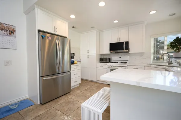 a kitchen with kitchen island a refrigerator sink and microwave