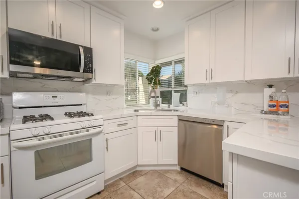 a kitchen with cabinets stainless steel appliances and a sink