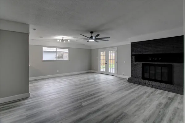 a view of an empty room with a fireplace and a window