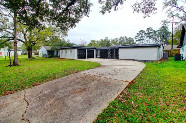 front view of a house with a yard and an trees