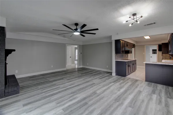 a view of a kitchen with a dishwasher a kitchen island hardwood floor and a ceiling fan