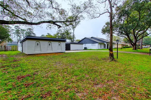 a view of a house with a big yard and large tree