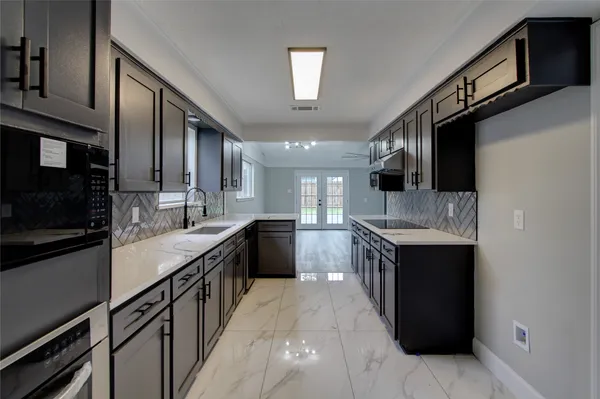 a kitchen with stainless steel appliances granite countertop a stove a sink and a refrigerator