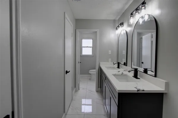 a bathroom with a double vanity sink and a mirror