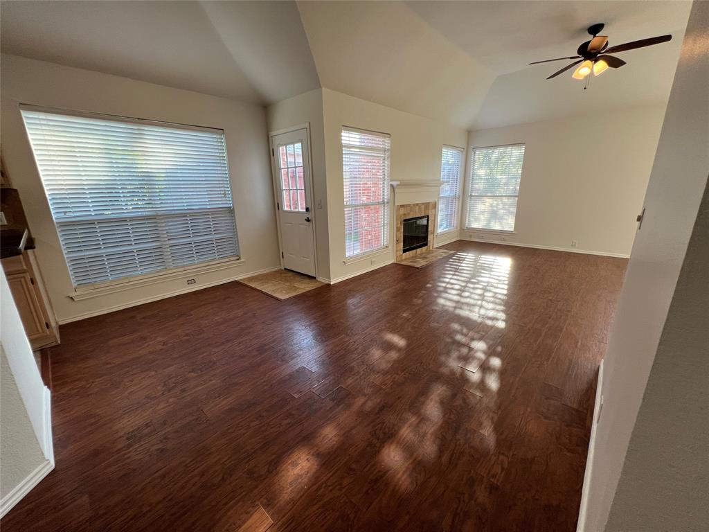 334 Touchdown Drive Irving, TX 75063 - Photo 25 of 32 Spacious living area featuring wood-finish flooring, vaulted ceilings, and a fireplace with a mantel