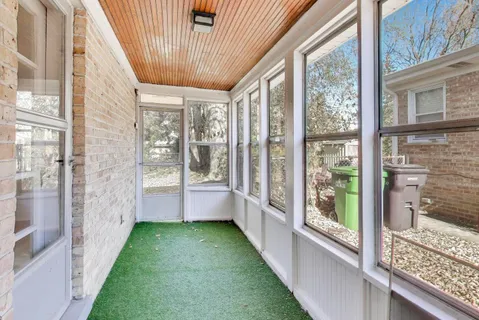 a view of porch with a floor to ceiling window and wooden floor