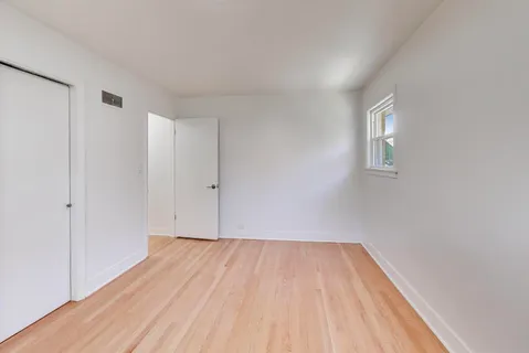 a view of room with wooden floor and white walls