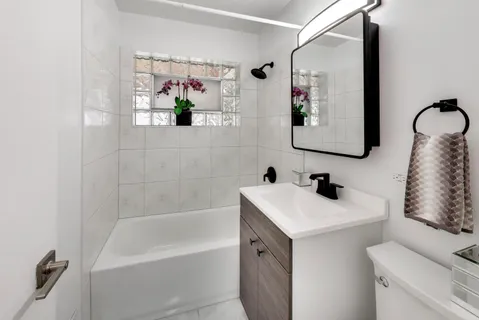 a bathroom with a sink mirror and a bathtub