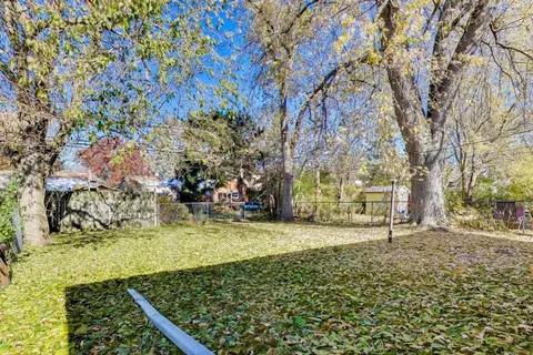 a view of a house with large trees and a barn