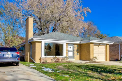 a view of a house with a large windows and a yard