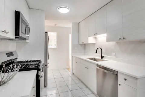 a kitchen with stainless steel appliances a sink stove and cabinets