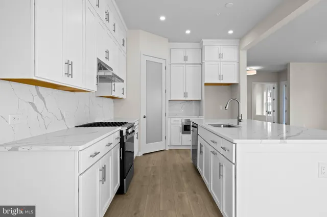 a view of kitchen with stainless steel appliances granite countertop cabinets and wooden floor
