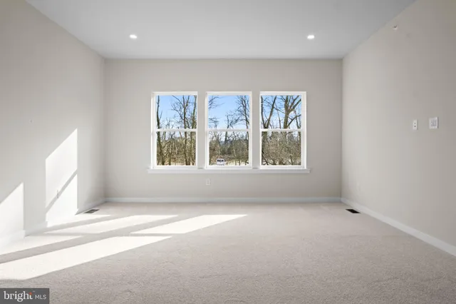 a view of an empty room with wooden floor and stairs