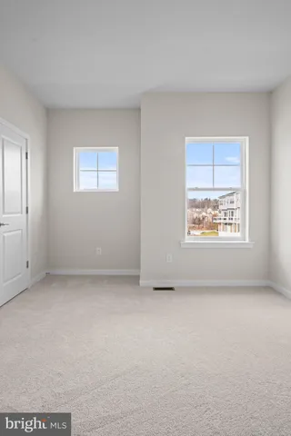 an empty room with windows and closet