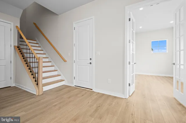 a view of a hallway with wooden floor and entryway