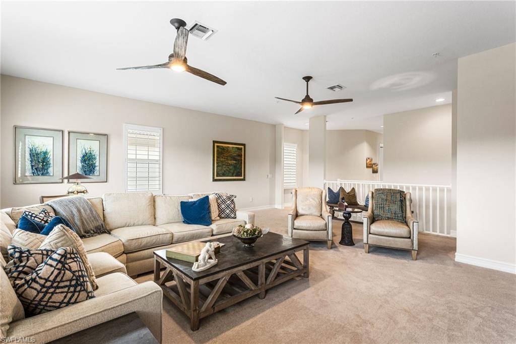 a living room with furniture a ceiling fan and a window
