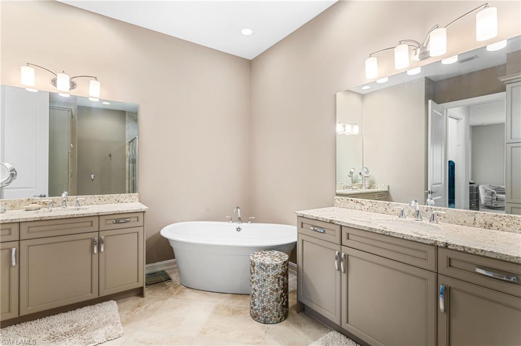 7825 Hawthorne Drive, Unit 2104 Naples, FL 34113 - Photo 20 of 43 a bathroom with a double vanity sink mirror and bathtub