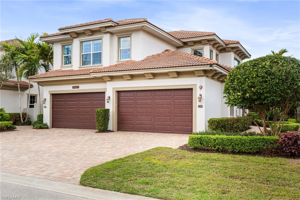 7825 Hawthorne Drive, Unit 2104 Naples, FL 34113 - Photo 2 of 43 a front view of a house with a yard and garage