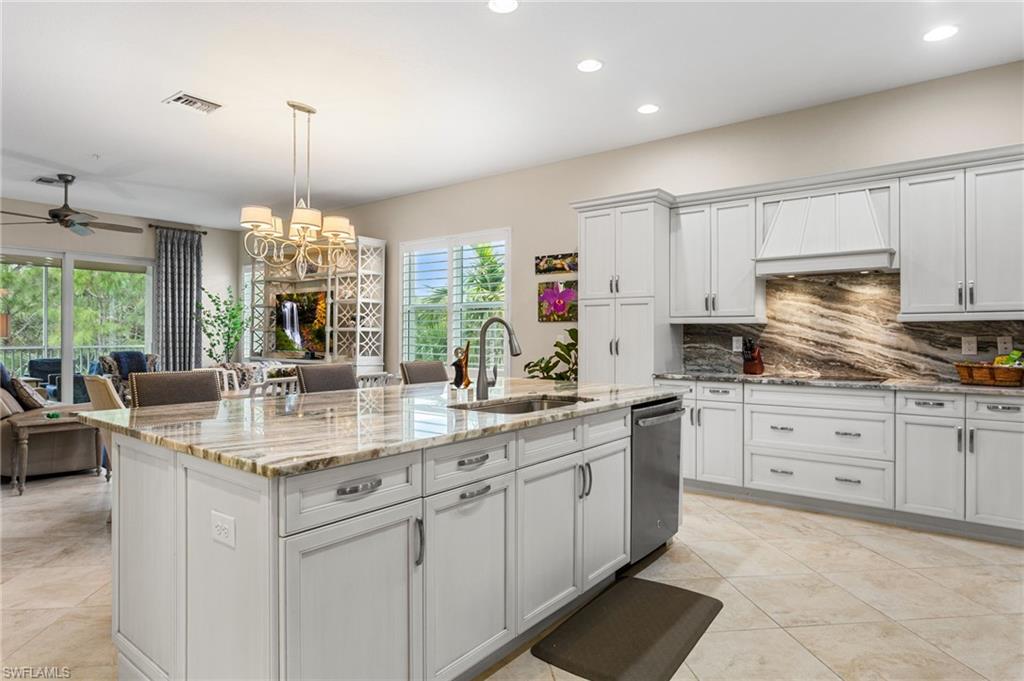 7825 Hawthorne Drive, Unit 2104 Naples, FL 34113 - Photo 10 of 43 a kitchen with kitchen island granite countertop a sink a stove a oven a counter space and cabinets