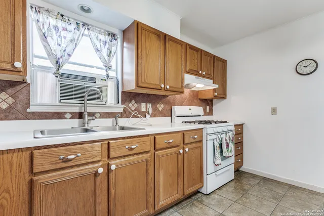 a kitchen with stainless steel appliances granite countertop a sink a stove and a microwave