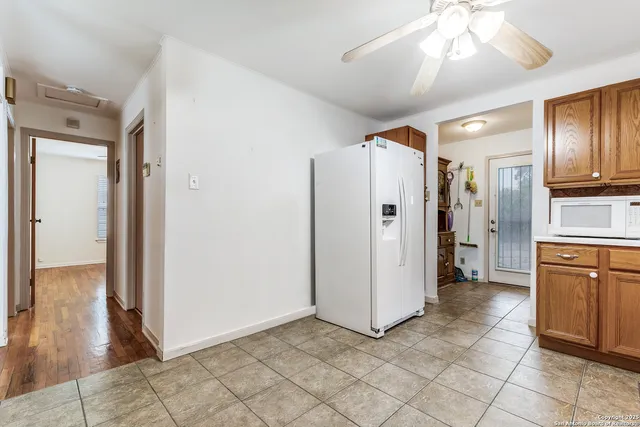 a view of a kitchen with a refrigerator and a stove top oven
