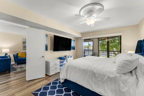 a bedroom with a bed and a flat tv screen on dresser