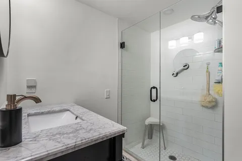 a bathroom with a granite countertop sink a toilet and shower