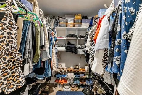 a view of walk in closet with clothes and shoes