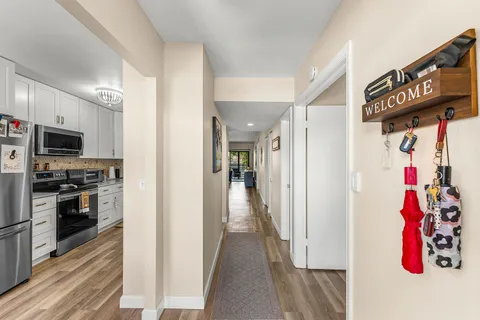 a view of a hallway with wooden floor and windows