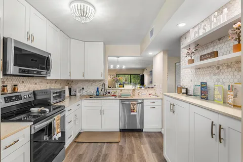 a kitchen with stainless steel appliances a sink stove and cabinets