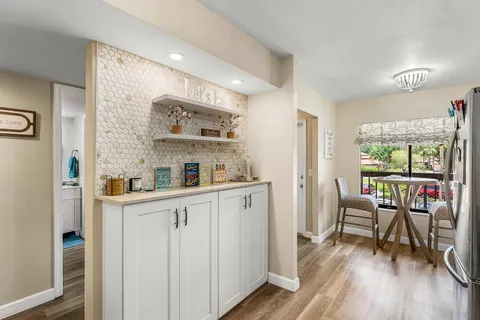 a kitchen with stainless steel appliances white cabinets and wooden floors