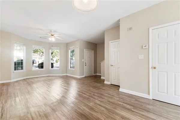 an empty room with wooden floor and windows