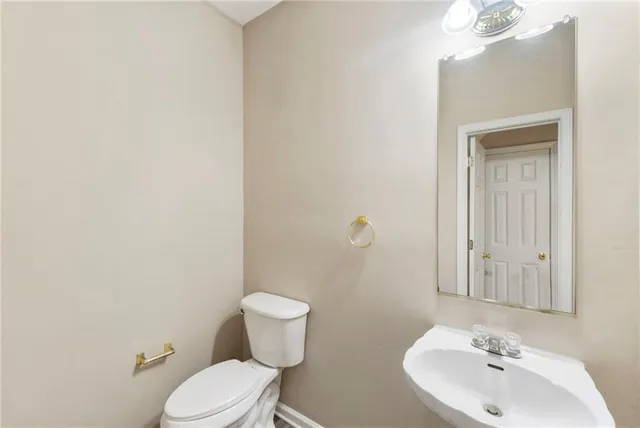 a bathroom with a toilet a sink and mirror