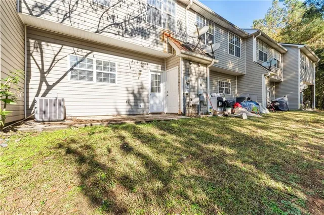 a view of a house with a large tree and a yard