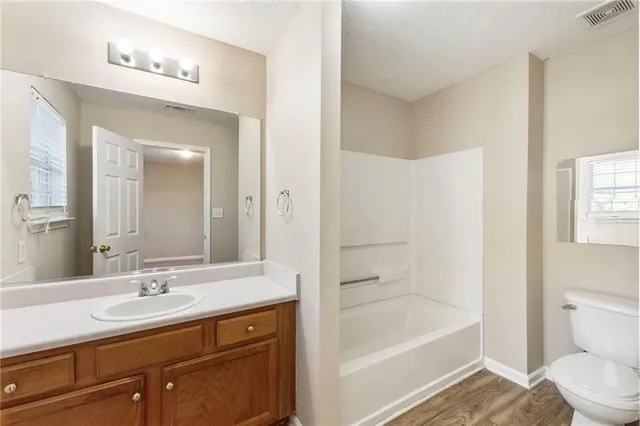 a bathroom with a tub sink toilet and a mirror