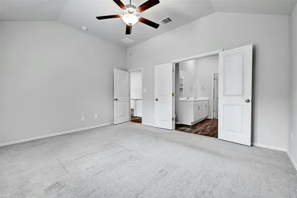 an empty room with closet and a ceiling fan