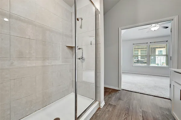 a bathroom with a bathtub and a glass door shower