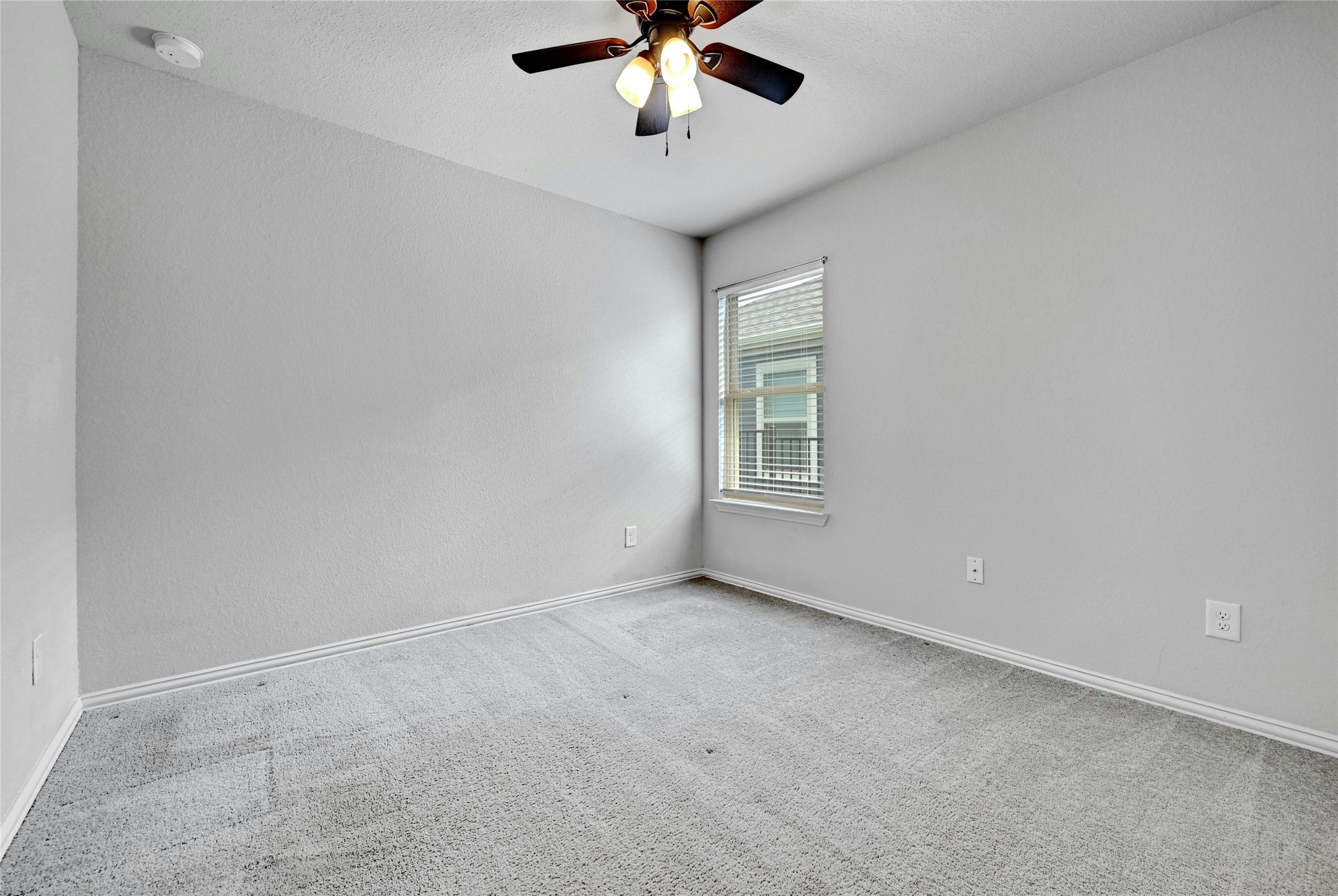 1384 Harwell Loop Kyle, TX 78640 - Photo 18 of 27 an empty room with windows and ceiling fan