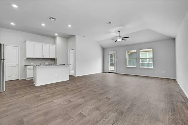 a view of an empty room with kitchen appliances and a window
