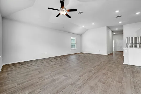 a view of empty room with wooden floor