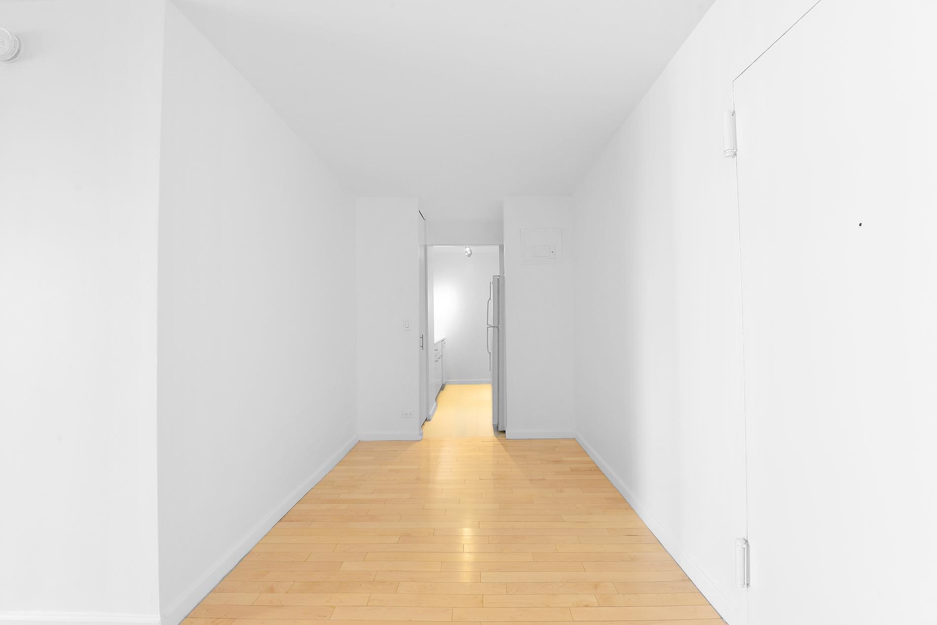 220 East 65th Street, Unit 8J Manhattan, NY 10065 - Photo 10 of 23 a hallway with wooden floor