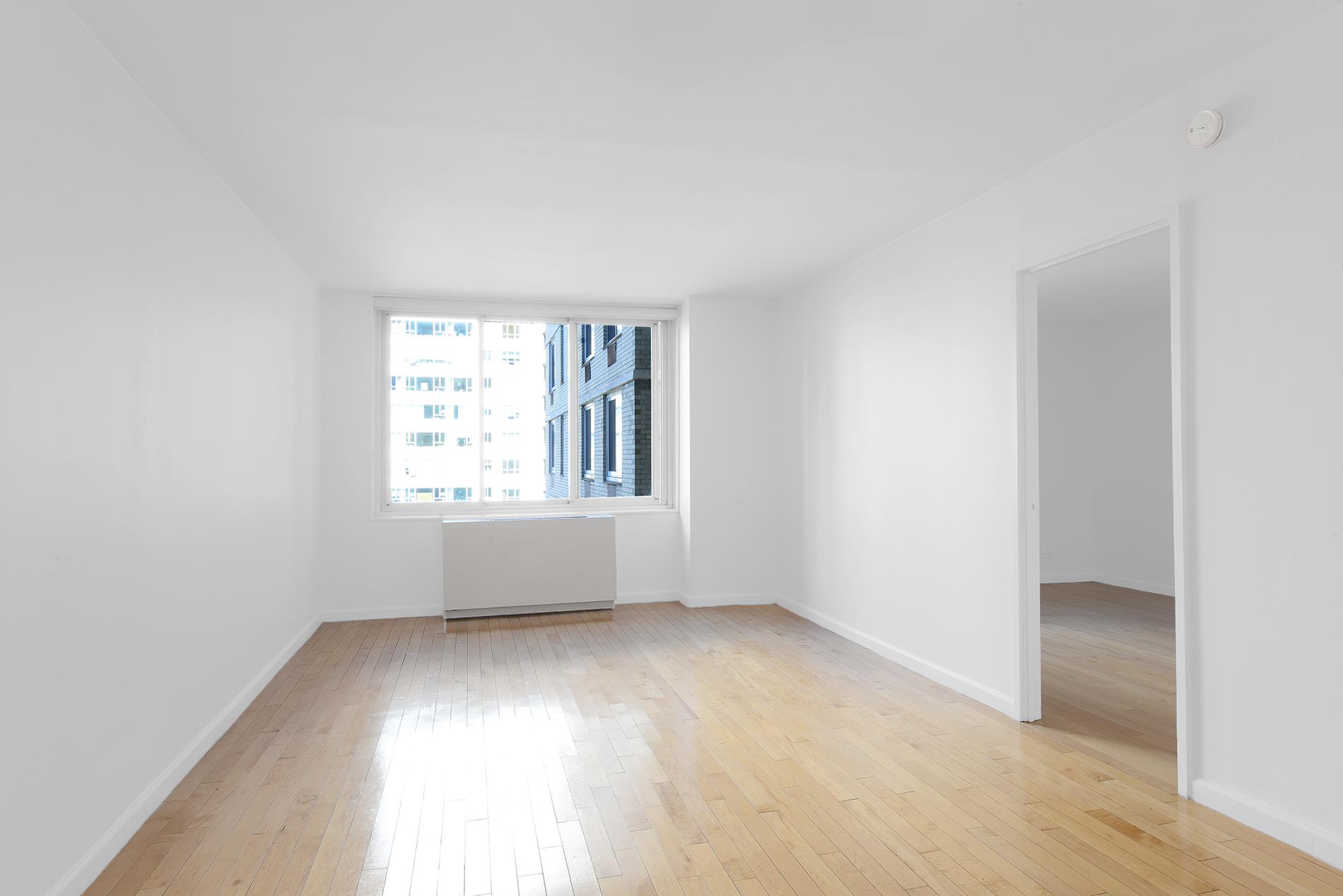 220 East 65th Street, Unit 8J Manhattan, NY 10065 - Photo 9 of 23 an empty room with windows
