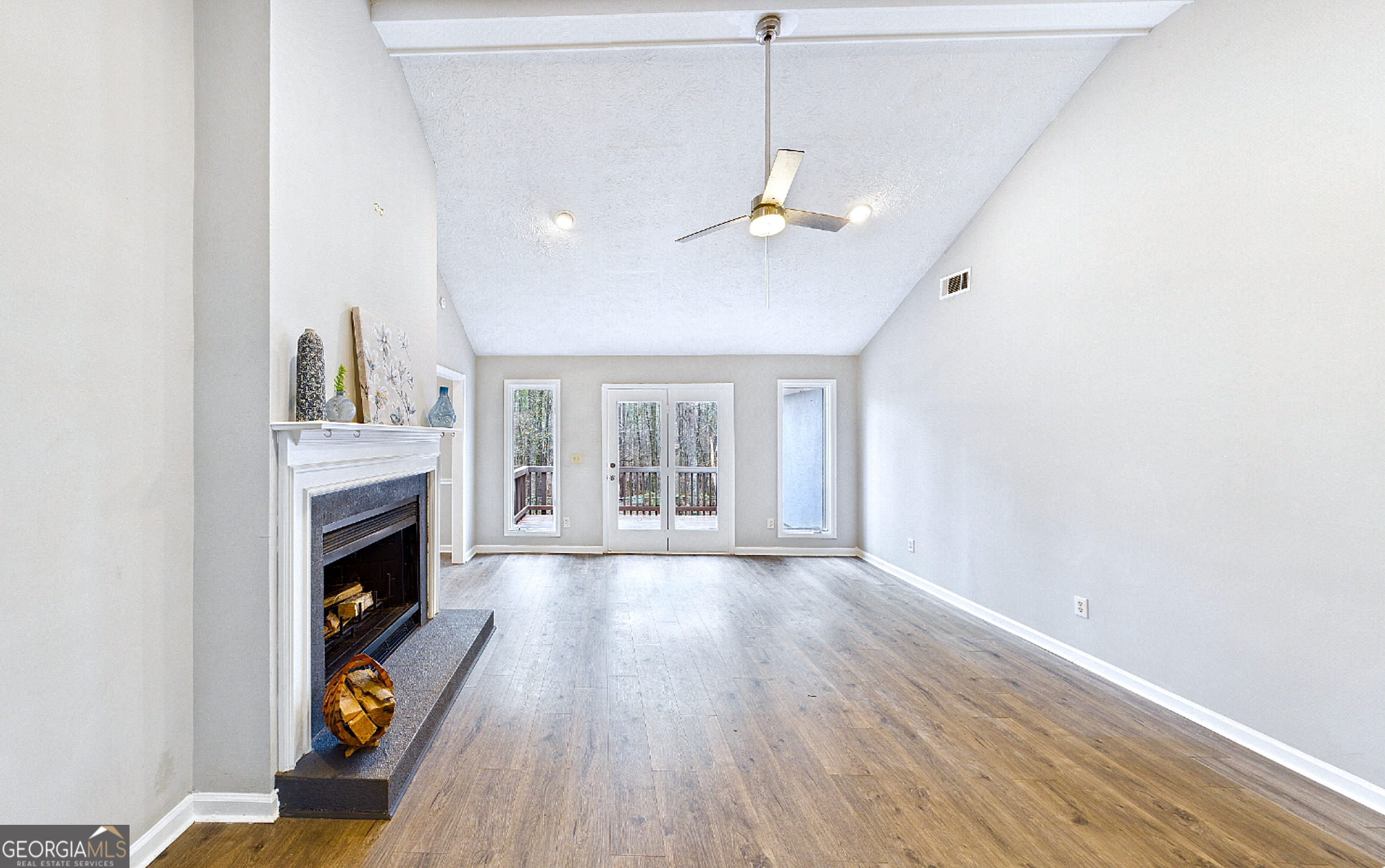 292 Blue Bird Trail Fortson, GA 31808 - Photo 5 of 45 a view of an empty room with wooden floor fireplace and a window