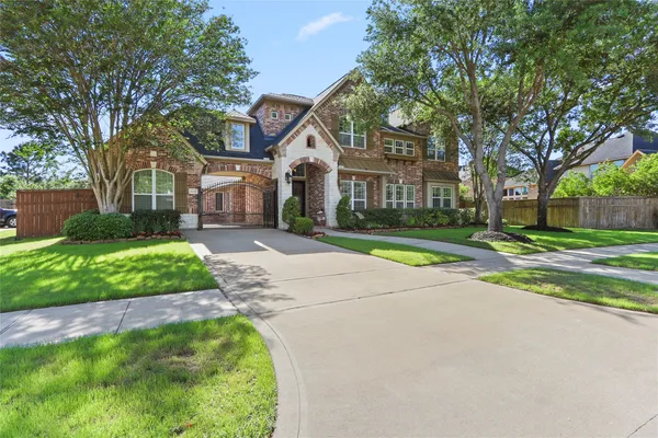a front view of a house with a yard and potted plants