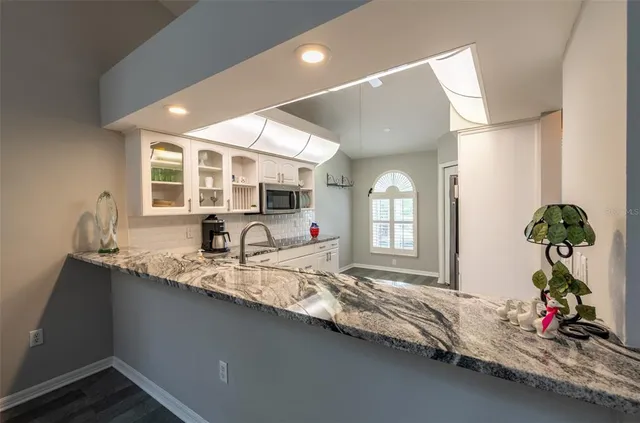 a hallway with a faucet a chandelier and wooden floor