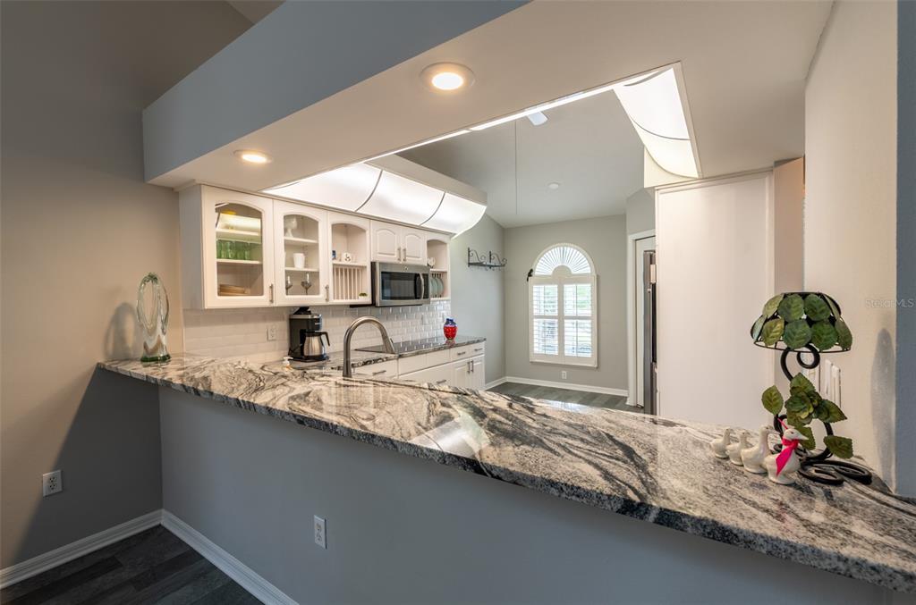 747 Inverie Drive Inverness, FL 34453 - Photo 12 of 40 a hallway with a faucet a chandelier and wooden floor