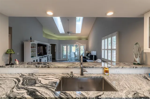 a view of a kitchen with kitchen island a sink and a large window