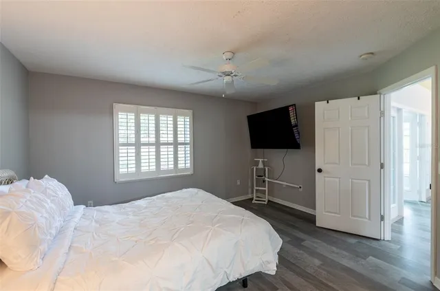 a bedroom with a bed and a flat tv screen on dresser